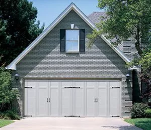 grey brick house with grey custom garage doors
