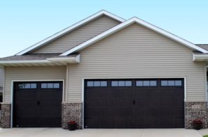 black Themacore garage doors on a home with white vinyl siding