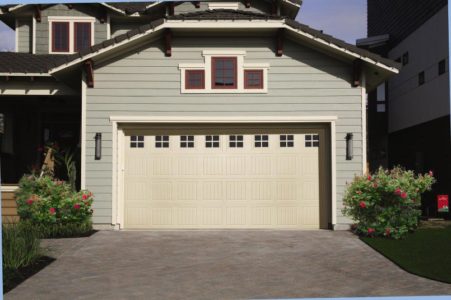 White paneled vinyl garage door with small windows in the top, on a home with pale green siding.